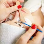 Eyelash extensions in a beauty salon. A young girl lies on a couch